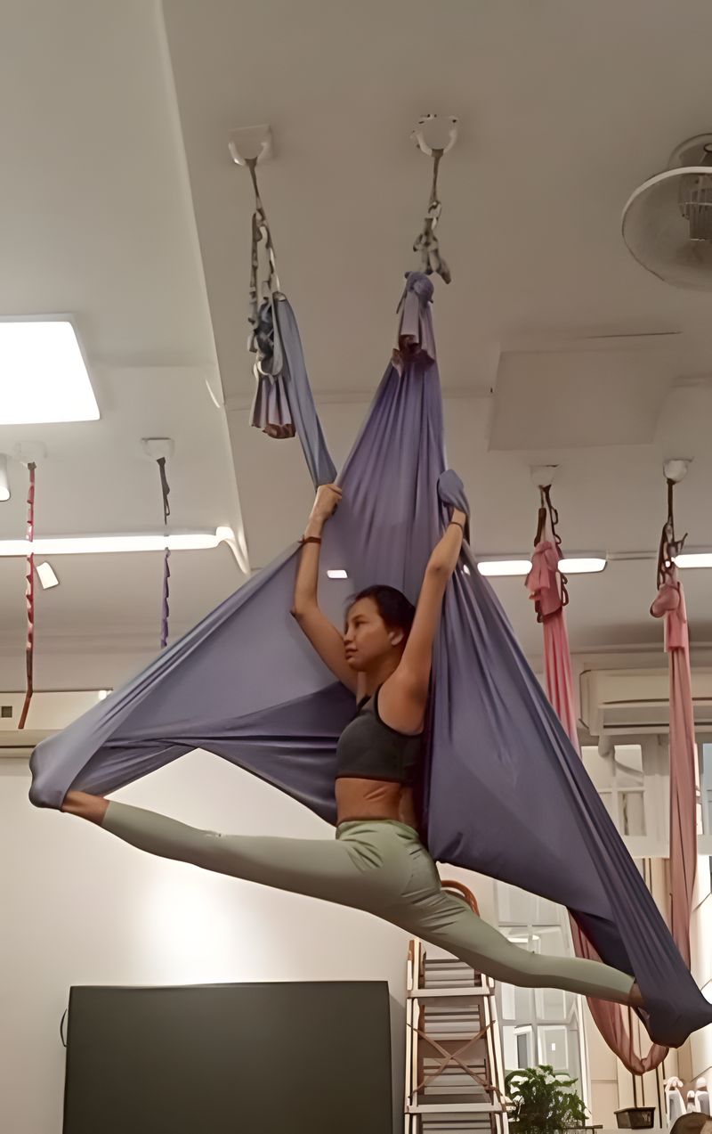 Elizabeth doing the splits in an aerial yoga hammock
